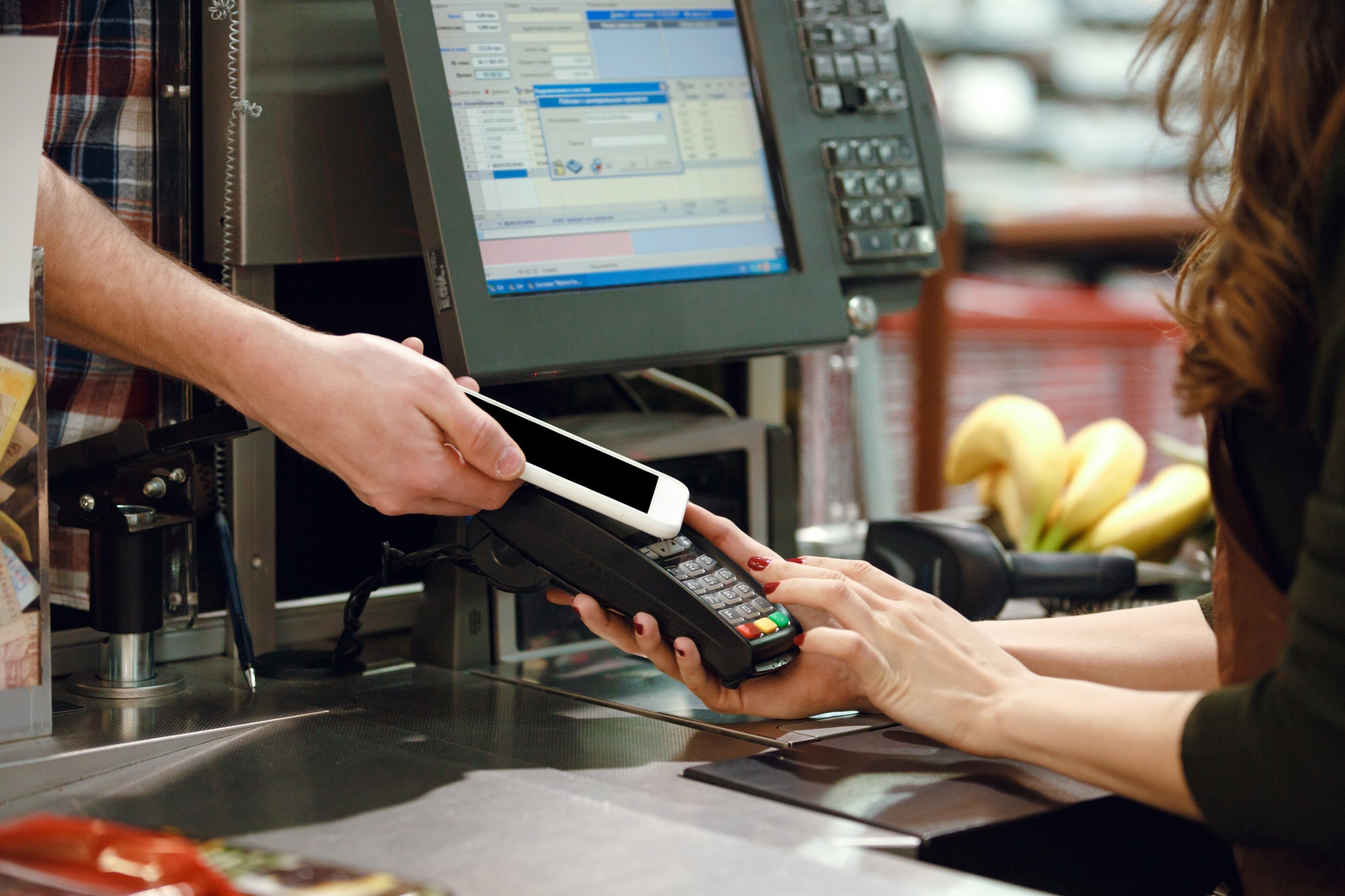 Cropped image of cashier woman create payment with phone app.